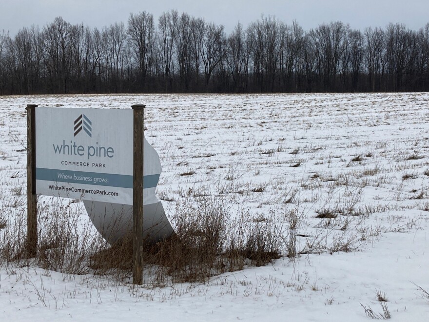 A sign for the White Pine Commerce Park stands in disrepair on the empty park.