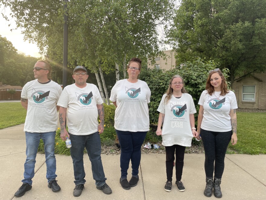  Five members of the Unity Council stand in a line in matching t-shirts. 