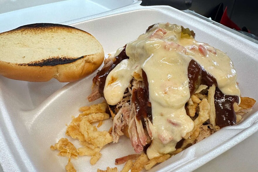 The Tramp Stamp with The Cover Up sandwich, which includes pulled pork, onion straws, pickles, and barbecue sauce, from Tattooed Hog BBQ in North Kansas City.