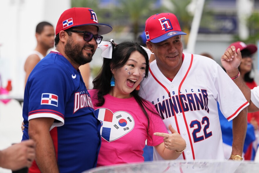 Bonnie Ramirez, center, a supporter of the South Korea baseball team, poses with Dominican Republic fans before a World Baseball Classic game between the Dominican Republic and South Korea, Friday, March 13, 2026, in Miami.