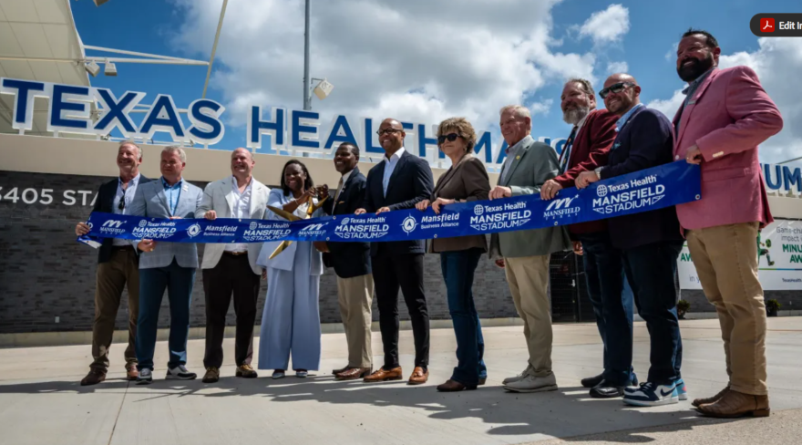 Community leaders and project developers pose with a ceremonial ribbon and scissors to commemorate the opening of Texas Health Mansfield Stadium July 1, 2026, in Mansfield.