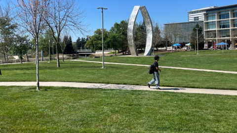 A student walks in front of the "Beginnings Sculpture" on the UC Merced campus on Thursday, March 26, 2026.
