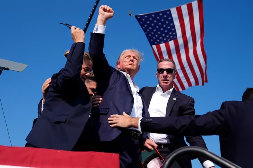 Republican presidential candidate former President Donald Trump gestures as he is surrounded by U.S. Secret Service agents as he leaves the stage at a campaign rally, Saturday, July 13, 2024, in Butler, Pa.