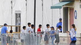 In this June 20, 2018 file photo, children walk in a line outside the Homestead Temporary Shelter for Unaccompanied Children, a former Job Corps site that now houses them in Homestead, Fla. (AP Photo/Brynn Anderson, File)