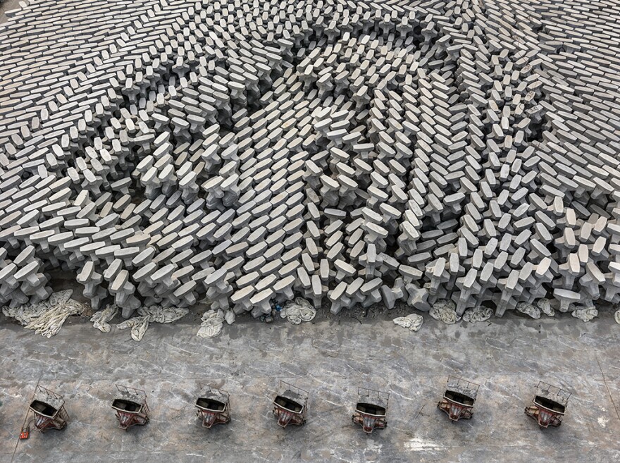 A tetrapod factory in Dongying, China. These concrete blocks are dropped into the ocean to create a barrier that protects low-lying oil refineries from rising sea levels. According to a recent scientific review, human beings have now produced enough concrete to cover the entire globe in a 2-millimeter thick layer.