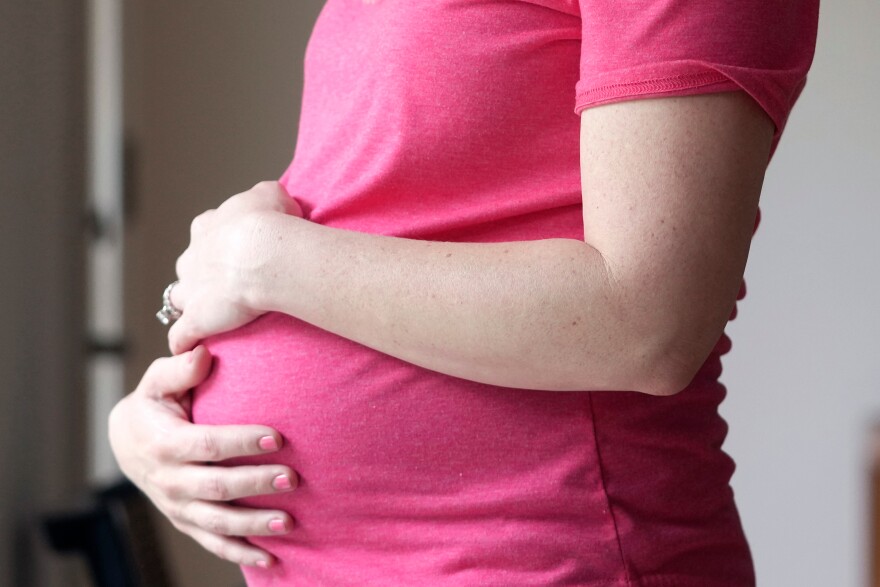 FILE - A pregnant woman stands for a portrait in Dallas, May 18, 2023. (AP Photo/LM Otero, File)