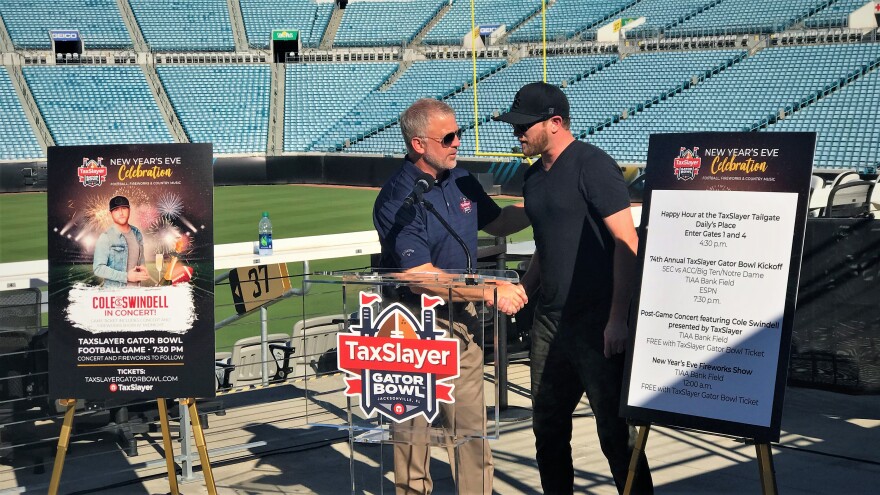 Jamie Shelton (left), Chairman of this year's TaxSlayer Gator Bowl, greets Country music star Cole Swindell at TIAA Bank Field.