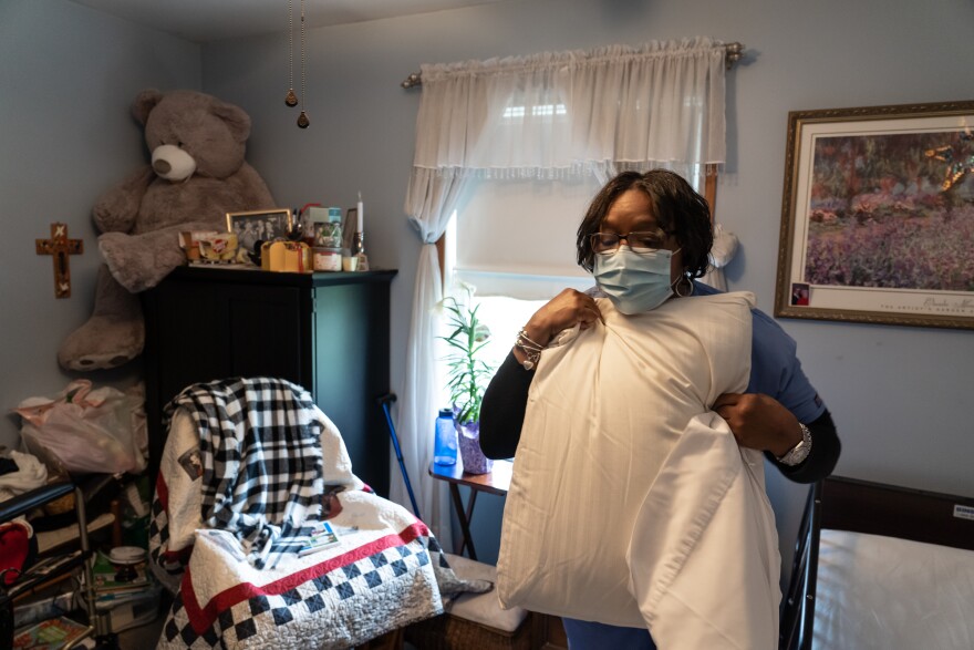 Excellacare Care Provider Sarah Sutherlin changes sheets and pillow cases while cleaning the room of her client Carmela Palamara, 92, of Brownstown at Palamara's home in Brownstown on Wednesday, April 14, 2021. Sutherlin has done in home personal care and