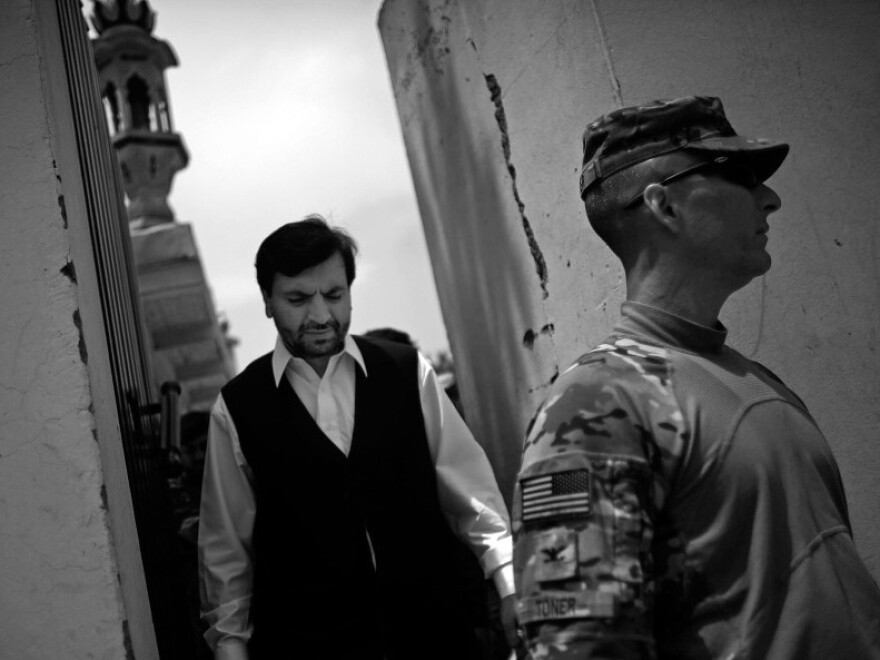 Governor Abdul Jabbar Naeemi walks through his compound with Col. Chris Toner after after a lunch and meetings in the governor's compound in the provincial capital.