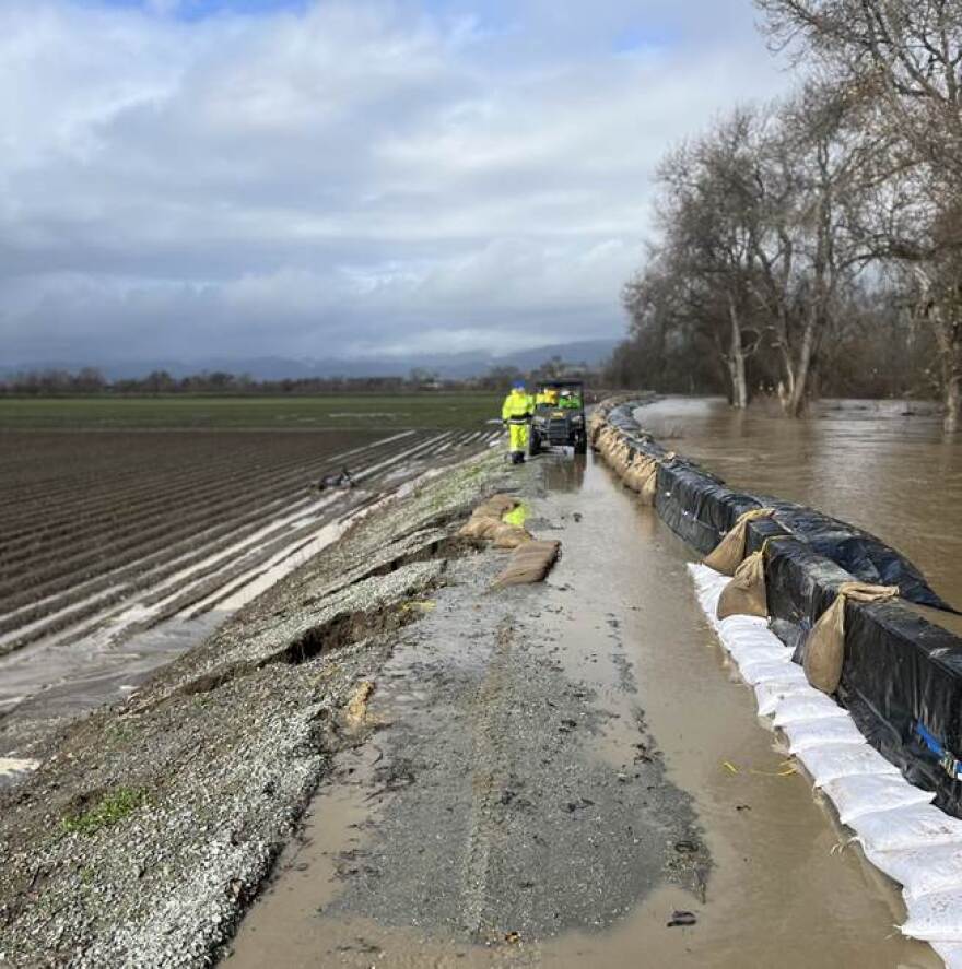 The Army Corps of Engineers pushed back a deadline for repairs on the Pajaro River levee until after this winter. In this photo taken during storms in January 2023, temporary flood walls placed on top of the Pajaro River levee barely prevented flood waters from rushing into the community below.