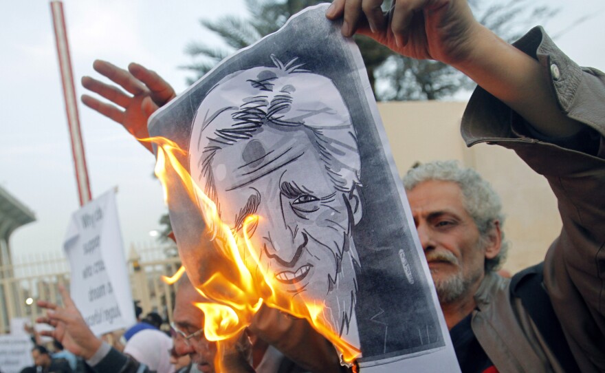 Egyptian activists burn a poster depicting Secretary of State John Kerry outside the Egyptian Foreign Ministry in Cairo on Saturday. Some accuse Kerry of supporting the Islamist government.