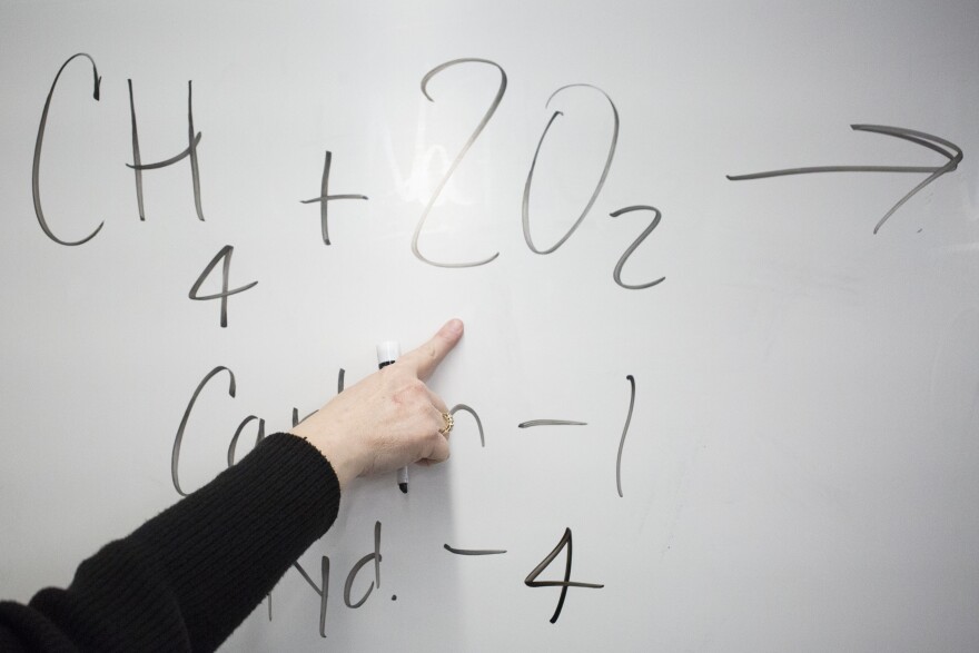 Science teacher Tracee Cummins' hand is seen pointing to an equation on a white board as she instructs students at New Tech Middle School in Manor in 2017.