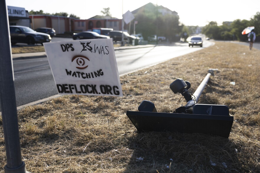 A downed Flock camera lays on the ground near North Lamar Boulevard last month.