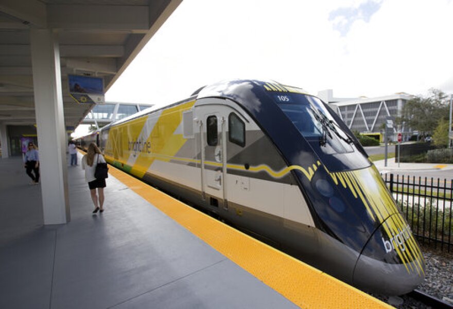 FILE - In this Jan. 11, 2018 file photo, a Brightline train sits at the station in Fort Lauderdale, Fla. Virgin Trains USA, which runs the Brightline train, is planning a high-speed train between Las Vegas and Southern California says construction could start late next year if bonds are approved by February. Virgin Trains USA executive Tina Quigley tells the Las Vegas Review-Journal that work will begin first in California, where state lawmakers last month approved a $3.25 billion bond request. Virgin is seeking approval in Nevada for $950 million in bonds. (AP Photo/Wilfredo Lee, File)