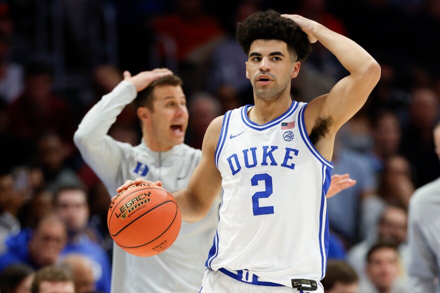 Duke guard Cayden Boozer (2) and head coach Jon Scheyer call a play during the first half of an NCAA college basketball game against Florida State in the quarterfinals of the Atlantic Coast Conference tournament in Charlotte, N.C., Thursday, March 12, 2026.