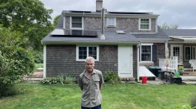 John Beach stands in his backyard in Yarmouth, where he can see newly installed solar panels. Beach lives in the Old Kings Highway Historic District, and the Historic District Committee denied his proposal to install solar panels that faced the street.