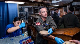 Capt. Justin Eckhoff, executive officer of USS Nimitz, serves cake during a celebration held to honor the 51st birthday of USS Nimitz (CVN 68) while underway in the Atlantic Ocean.