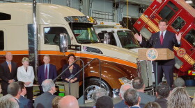 Florida Gov. Ron DeSantis speaking on Monday at Kenworth of Jacksonville, joined by state lawmakers and business leaders. (left)