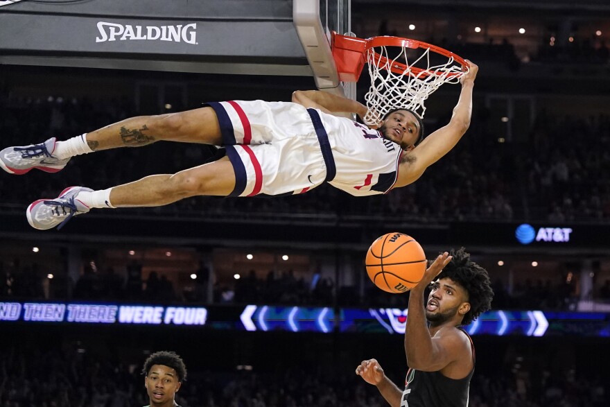 Connecticut guard Andre Jackson Jr. dunks the ball over Miami forward Norchad Omier, right, during the second half of a Final Four college basketball game in the NCAA Tournament on Saturday, April 1, 2023, in Houston.