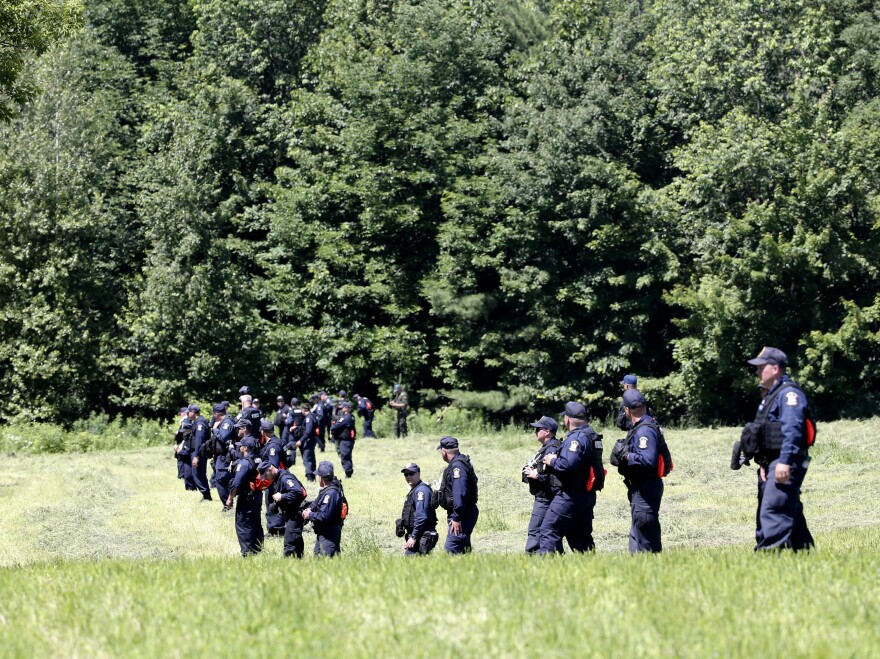 Corrections officers walk through a field in Malone, N.Y., during a search for two escaped prisoners from Clinton Correctional Facility.