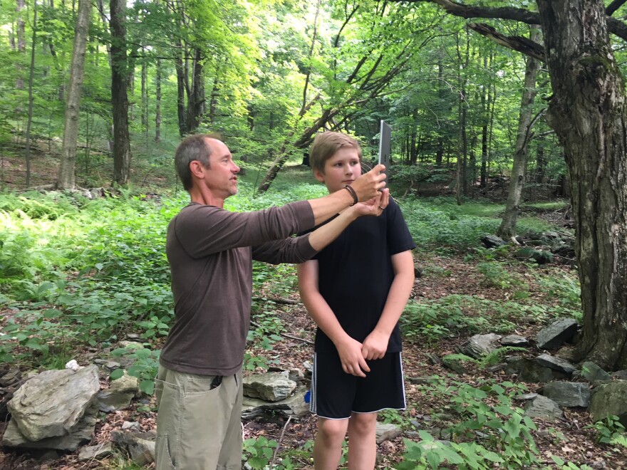 Teacher Steve Butz, left, helps Lucas Kindel with an iPad that will take a 3D photo on a site Butz thinks dates back to the end of the 18th century.