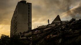 A man stands atop a mountain of rubble three days after twin earthquakes struck, in La Guaira, Venezuela, Saturday, June 27, 2026.