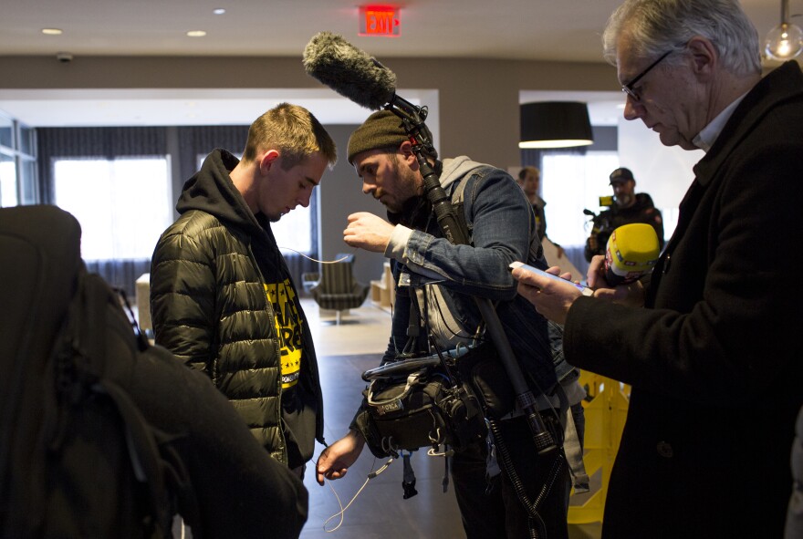 A camera crew member readies Zeif's microphone before his interview.