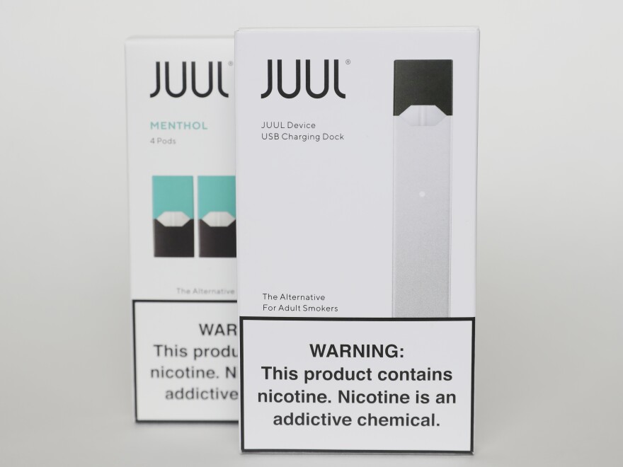 FILE - This Tuesday, Feb. 25, 2020 file photo shows packaging for an electronic cigarette and menthol pods from Juul Labs, in Pembroke Pines, Fla. Juul Labs Inc. will pay $40 million to North Carolina and take more action to prevent underage use and sales, according to a landmark legal settlement announced Monday, June 18, 2021, after years of accusations that the company had fueled an explosion in teen vaping. (AP Photo/Brynn Anderson)