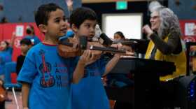 indergartners at Sítʼ Eetí Shaanáx̱ Glacier Valley Elementary School play paper violins as part of a Lingít language immersion and music program on Dec. 9, 2022. (Photo by Andrés Javier Camacho/KTOO)