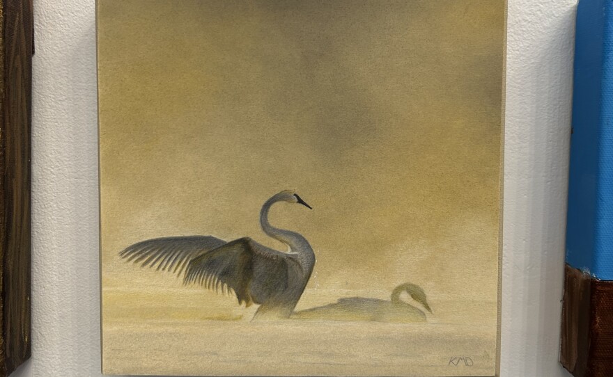 A mixed media art piece of two swans swimming in the water with a yellow background.