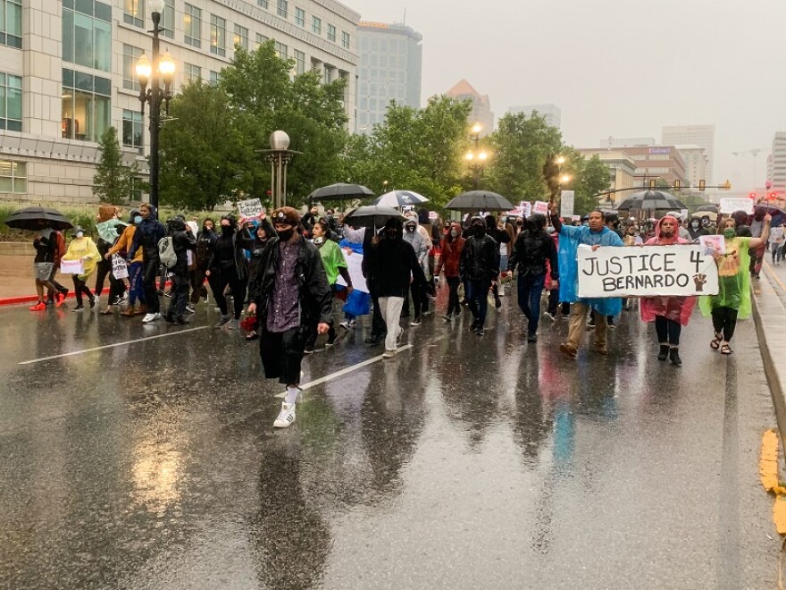 Photo of protesters marching down a rainy street.