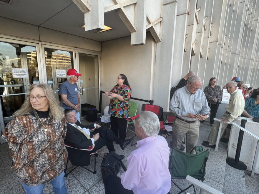 Dozens of people, who hope to attend the State Board of Education meeting, wait outside Thursday. The crowd exceeded meeting room capacity.
