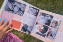 a baby scrapbook with a person's manicured hand in the photo