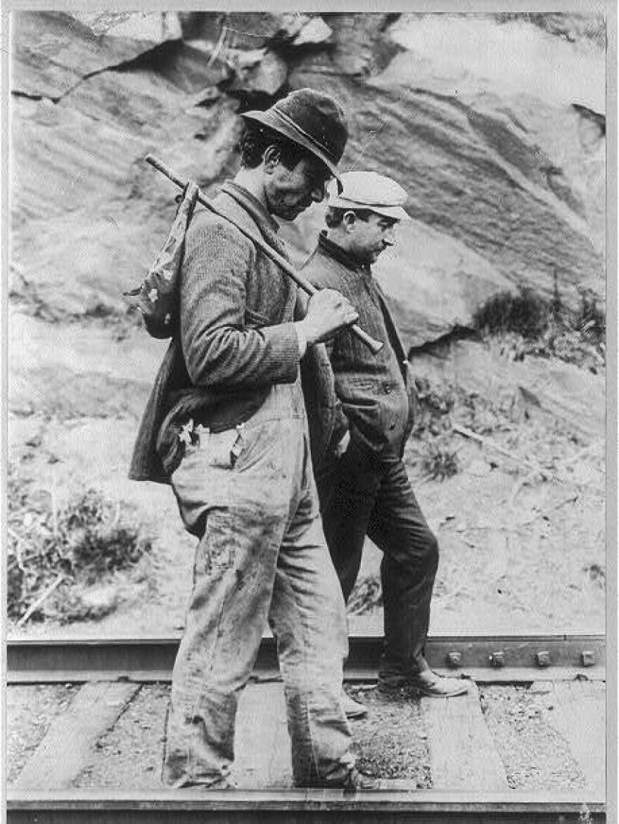 Two hobos walking the rails.