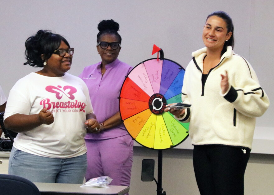 Nicole Miller, left, founder of Blossoming Butterfly Inc., on stage with a member of STOP Cancer, asking the group trivia questions about her presentation. (Catherine Chapman/WUFT News)