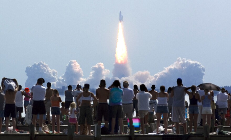 Crowds watch as the Space Shuttle Discovery lifts off from Kennedy Space Center in 2005. NASA is asking people to stay away from this week's launch due to the pandemic.