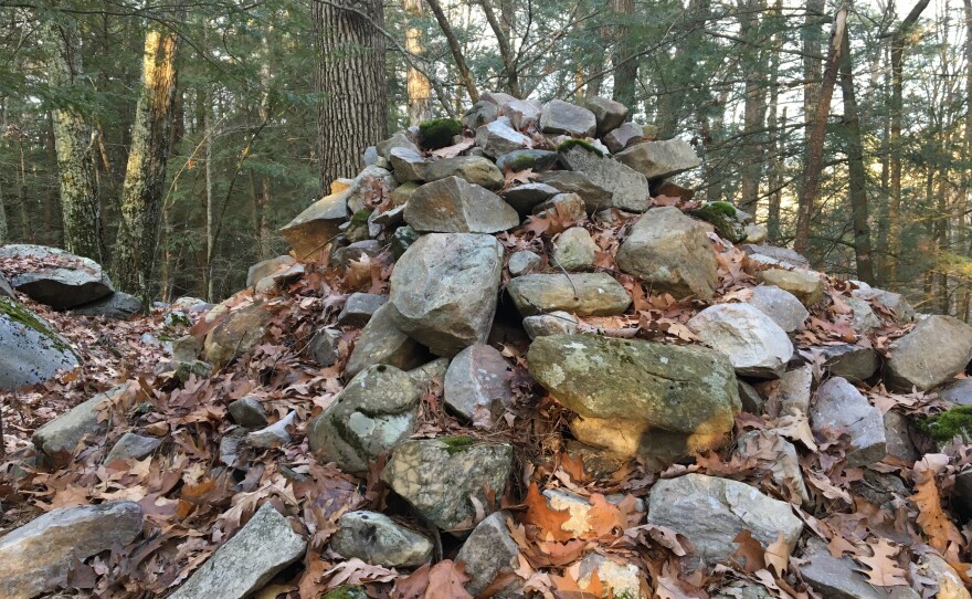 A Williams College student intern, working with the historic preservation office of the Stockbridge-Munsee tribe, researched content for new signs to describe the cultural significance of this cairn at Monument Mountain in Great Barrington, Massachusetts.