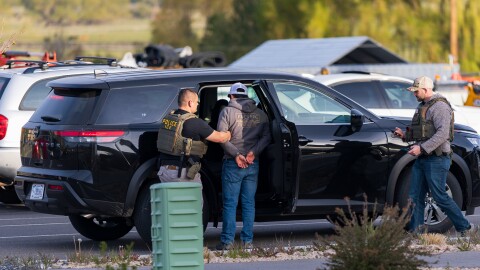 Agents take a man into custody near the Smith's gas station in Heber City, April 21, 2026.