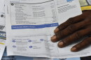 An up-close photo of a Tampa Electric Power bill shows charges totaling $338 with a man’s hand resting on the bottom of the page.