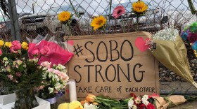 Visitors have left signs, flowers and notes at the makeshift memorial site outside the Boulder King Soopers.