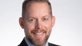 David Zook, a white man with a beard, smiles. He is wearing a suit.