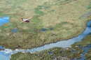 In this undated file photo provided by the U.S. Fish and Wildlife Service, an airplane flies over caribou from the Porcupine Caribou Herd on the coastal plain of the Arctic National Wildlife Refuge in northeast Alaska. 