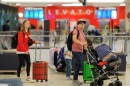 Two people carrying baggage walking through Tampa International Airport.