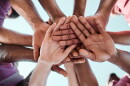 People, teamwork and hands together in collaboration, goals or community for motivation below. Closeup of group piling in team building, solidarity or trust in support for sports, rugby or match.