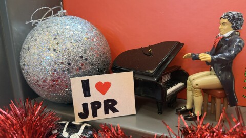 A Window display with a Beethoven figurine at the piano with Christmas decorations and a sign that says "I love JPR"
