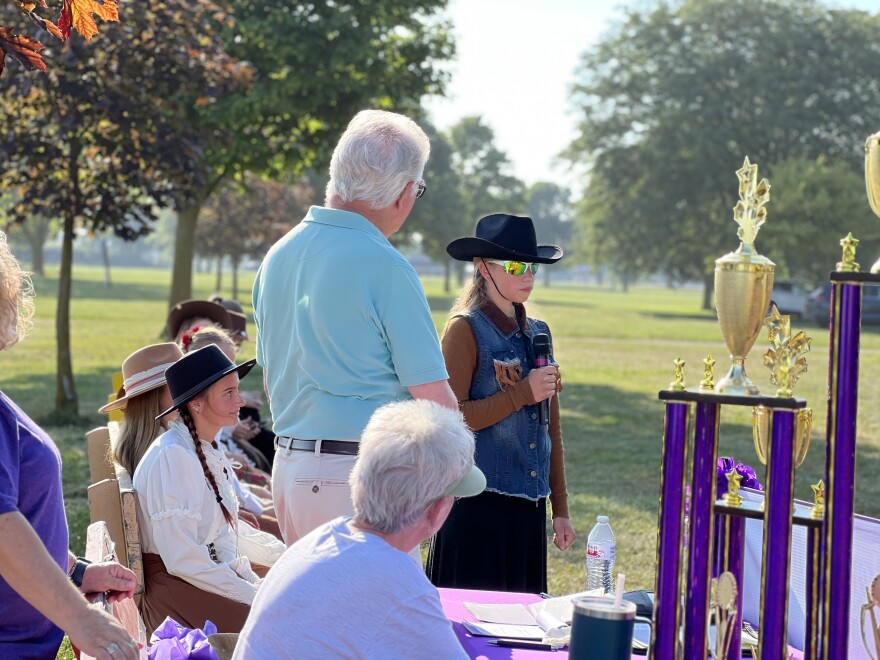 A young competitor answers questions about her Annie Oakley costume during the sharpshooting competition.