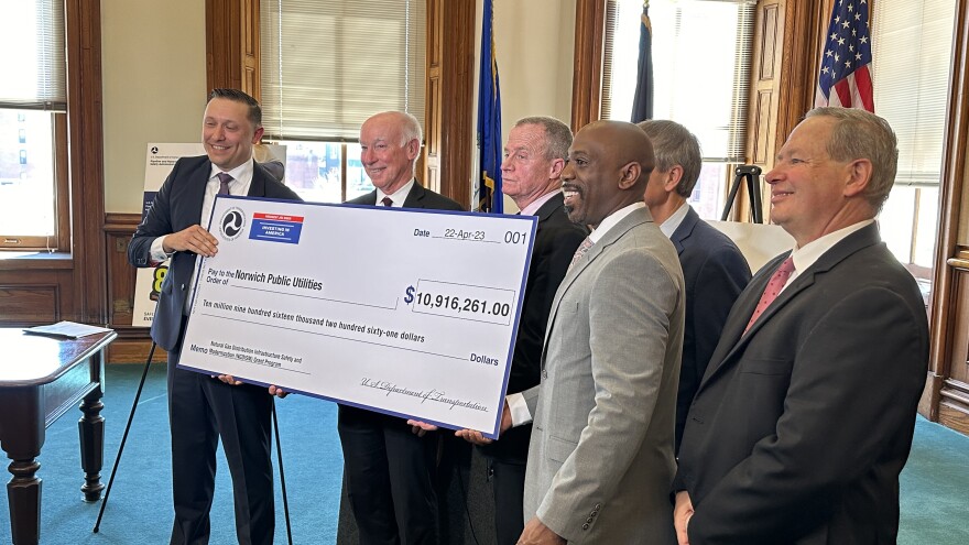 Elected officials, including U.S. Representative Joe Courtney, hold a check for nearly $11 million.