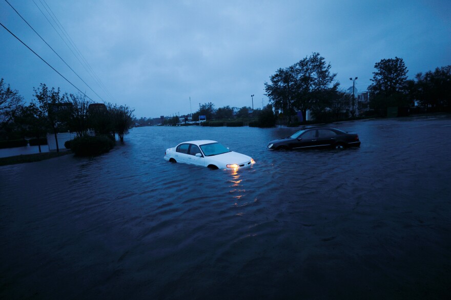 An abandoned car's hazard lights continue to flash as it sits submerged in rising floodwaters on Saturday morning in North Carolina.