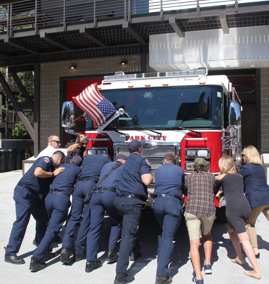Firefighters and elected officials push in the new fire truck Thursday.