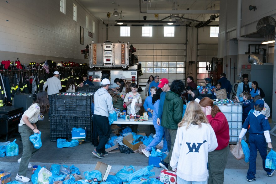 Dozens of scouts and their families sort through thousands of donated canned goods in a fire station for the annual Scouting for Food drive in Clayton, Mo. 